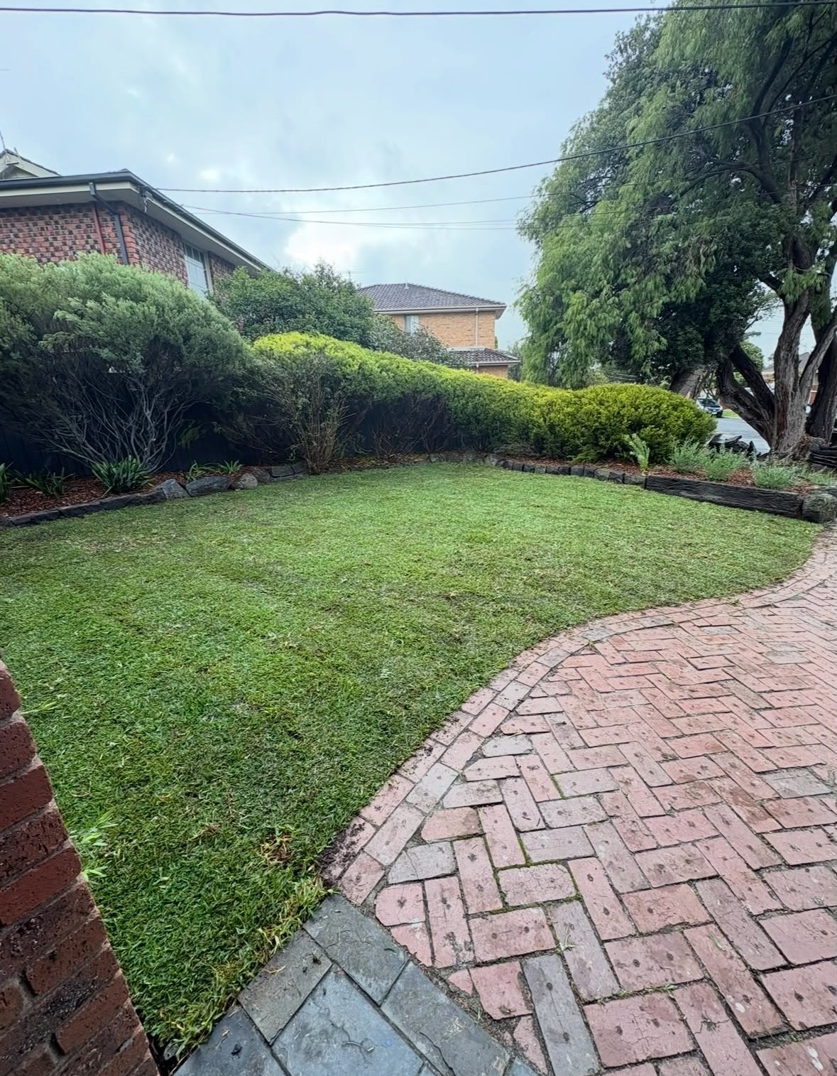 Finished lawn with curved brick paving