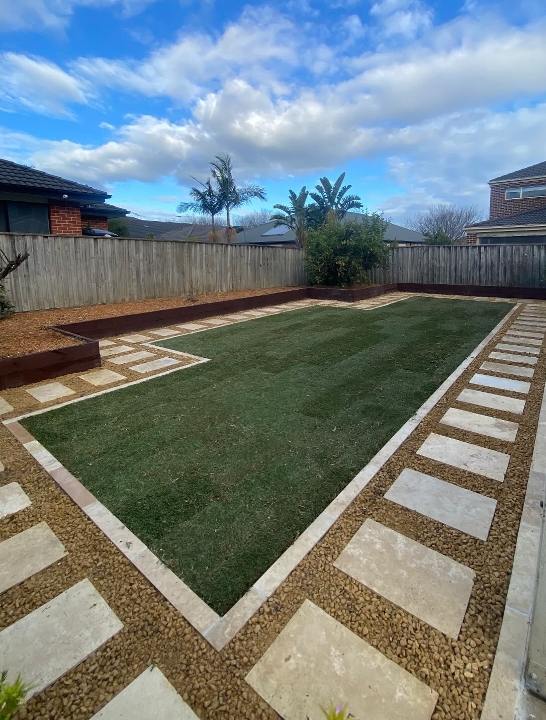 Fresh lawn framed by pavers and gravel